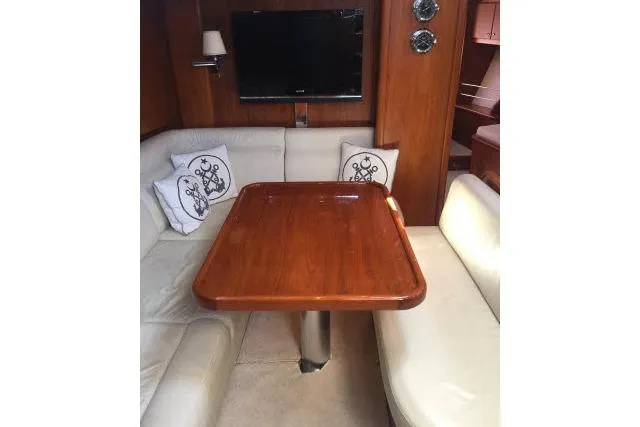 Slide: The Image of Interior of 1997 Gorbon Custom 66 yacht with wooden table and cushioned seating. - 126