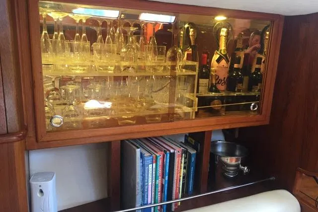 Slide: The Image of Luxurious Gorbon Custom 66 yacht interior with glassware, wine bottles, and books, 1997 model. - 132
