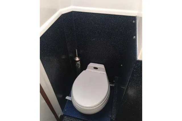 Slide: The Image of Toilet in 1997 Gorbon Custom 66 yacht, featuring sleek dark paneling. - 164