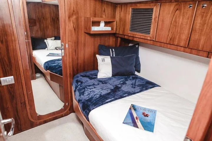 Slide: The Image of Luxurious cabin interior of 1997 Gorbon Custom 66 yacht with cozy bedding and wooden finish. - 168