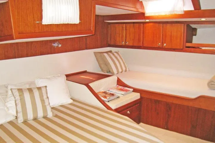 Slide: The Image of Luxurious cabin interior of 1997 Gorbon Custom 66 yacht with wooden finishes and striped cushions. - 174