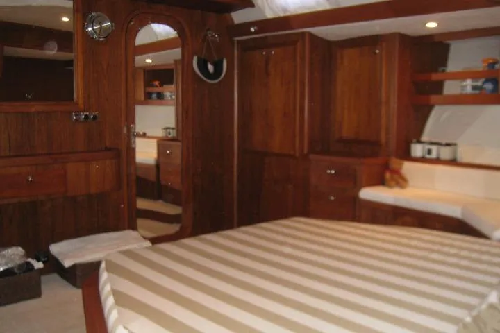Slide: The Image of Luxurious wooden interior of 1997 Gorbon Custom 66 yacht cabin with striped bedding. - 176