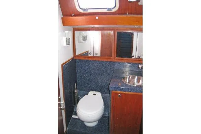 Slide: The Image of 1997 Gorbon Custom 66 yacht bathroom with wooden cabinets and stainless steel sink. - 178