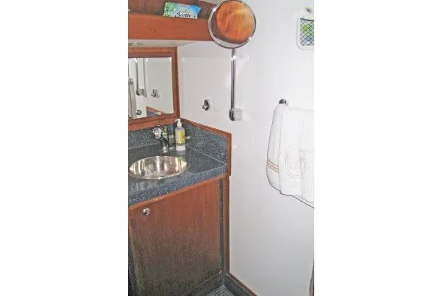 Slide: The Image of 1997 Gorbon Custom 66 yacht bathroom with sink, mirror, and wooden cabinetry. - 179