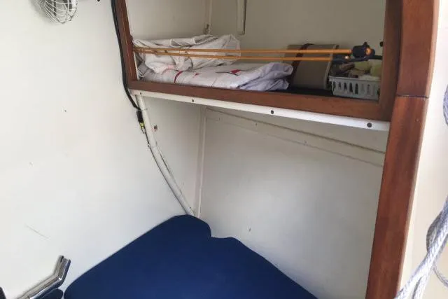 Slide: The Image of Interior cabin of 1997 Gorbon Custom 66 yacht with blue bedding and storage shelf. - 183