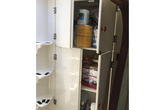 Slide: The Image of Open storage cabinet on Gorbon Custom 66 yacht, showcasing various maintenance supplies. - 184