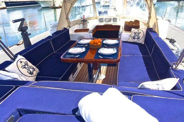 Slide: The Image of Luxurious 1997 Gorbon Custom 66 yacht interior with blue seating and elegant dining setup. - 187