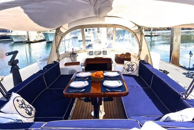 Slide: The Image of Luxurious 1997 Gorbon Custom 66 yacht interior with elegant dining setup and plush blue seating. - 188