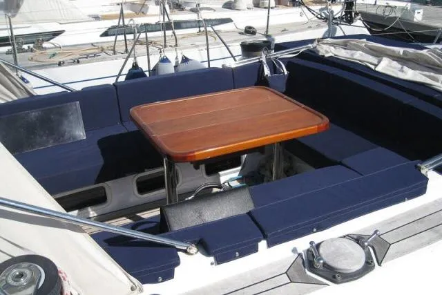 Slide: The Image of Cockpit of 1997 Gorbon Custom 66 yacht with wooden table and navy seating. - 192