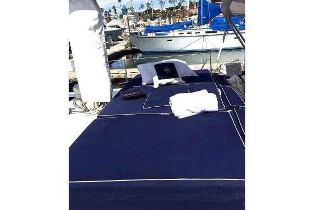 Slide: The Image of Luxurious 1997 Gorbon Custom 66 yacht deck with navy bedding at marina. - 194