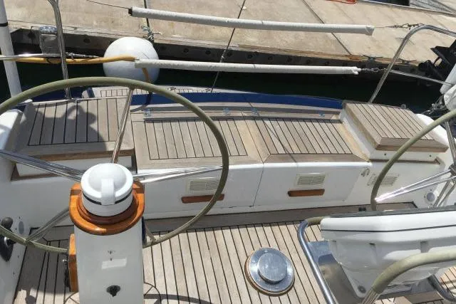 Slide: The Image of 1997 Gorbon Custom 66 yacht deck with dual steering wheels and wooden seating. - 195