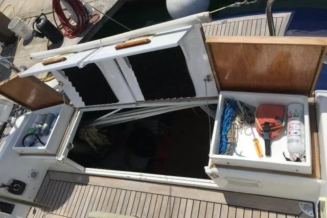 Slide: The Image of Open storage compartments on a 1997 Gorbon Custom 66 yacht deck, revealing equipment and supplies. - 196