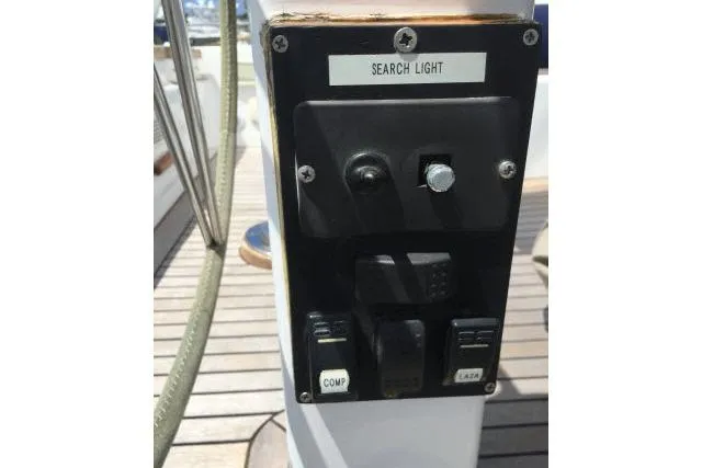 Slide: The Image of Control panel on a 1997 Gorbon Custom 66 yacht, featuring searchlight and switches. - 205
