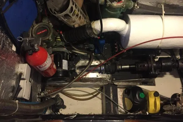 Slide: The Image of Engine room of a 1997 Gorbon Custom 66 yacht with fire extinguisher and mechanical components. - 234