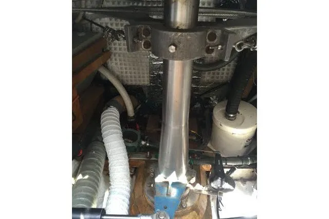 Slide: The Image of Engine compartment of a 1997 Gorbon Custom 66 yacht, showcasing mechanical components and hoses. - 235