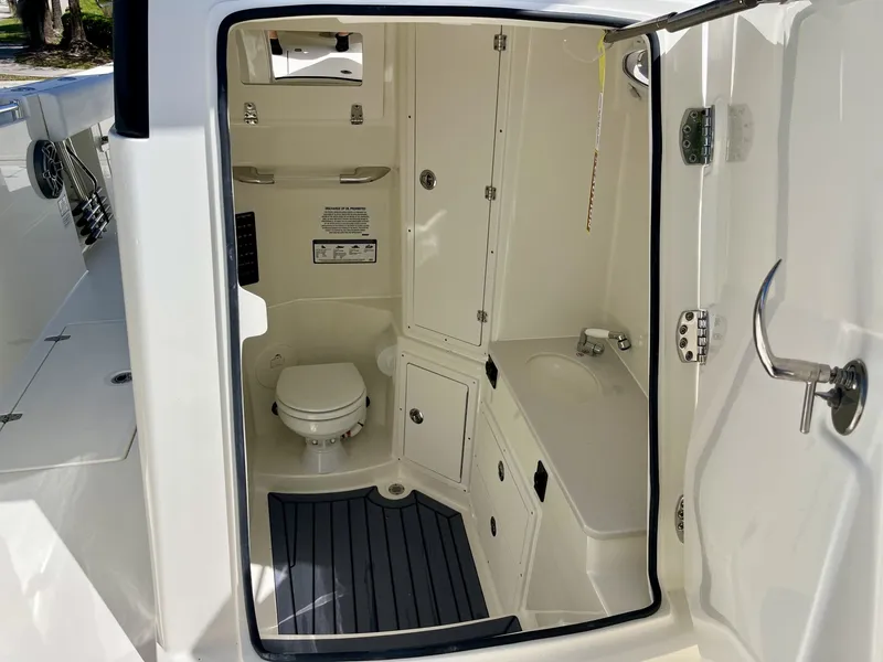 Slide: The Image of Interior of 2026 Cobia 320 Center Console with toilet and sink. - 23