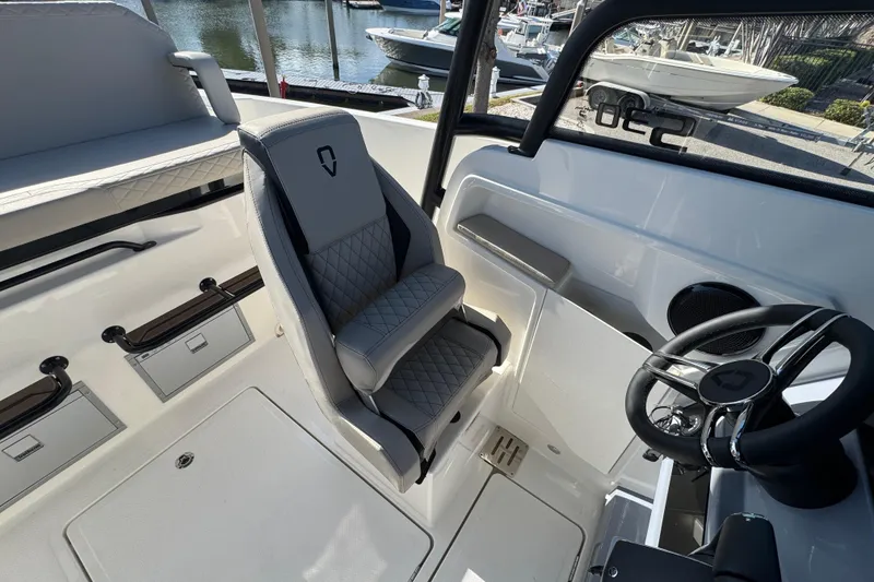 Slide: The Image of 2026 Navan S30 boat interior with steering wheel and cushioned seat by the dock. - 11