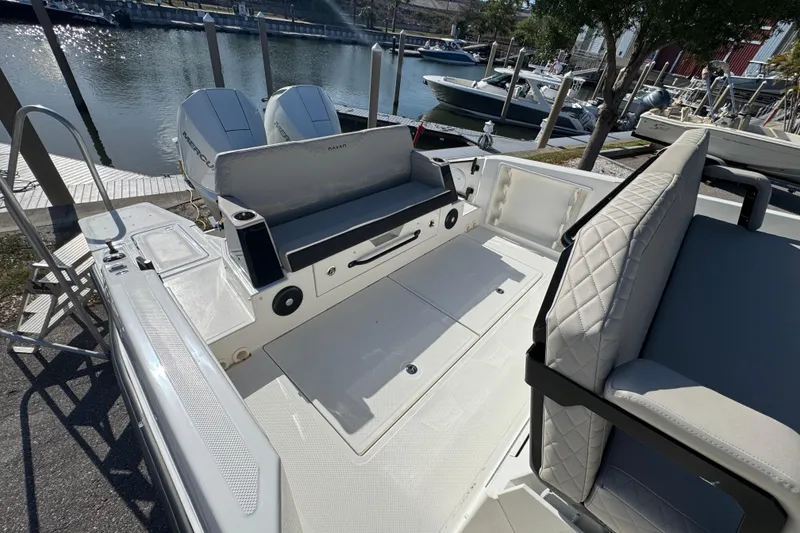 Slide: The Image of 2026 Navan S30 boat interior with seating and storage, docked by the water. - 5
