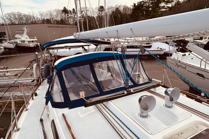 Slide: The Image of 2004 Sabre 426 sailboat with blue canopy, docked in a marina. - 11