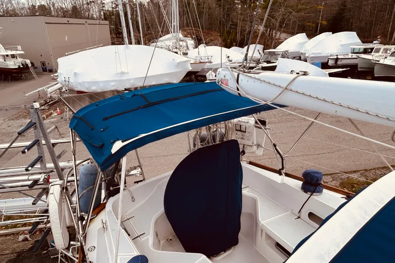 Slide: The Image of 2004 Sabre 426 sailboat with blue canopy in a boatyard, surrounded by covered vessels. - 12