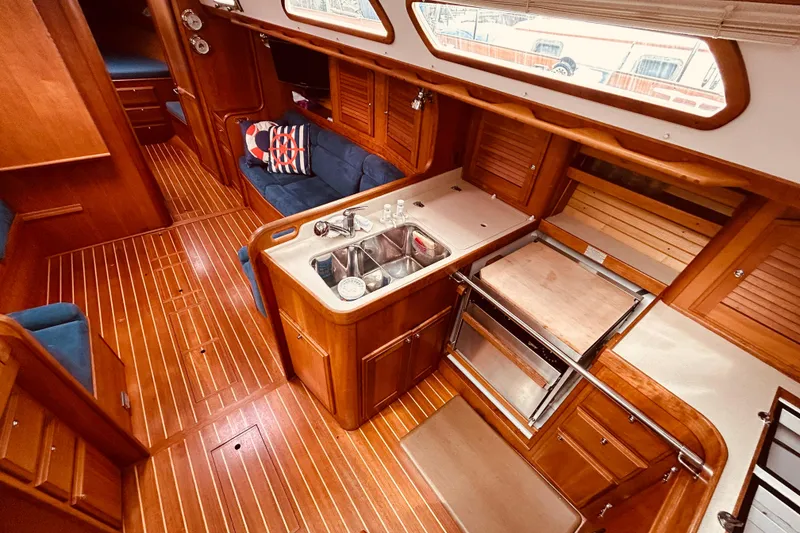 Slide: The Image of Luxurious 2004 Sabre 426 yacht interior with wooden flooring and modern kitchen amenities. - 23