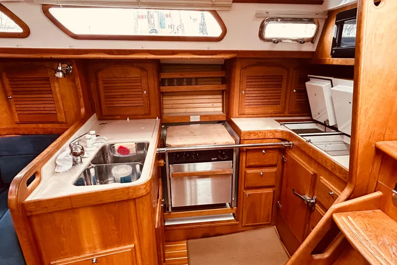 Slide: The Image of Interior of 2004 Sabre 426 yacht kitchen with wooden cabinetry and stainless steel sink. - 27