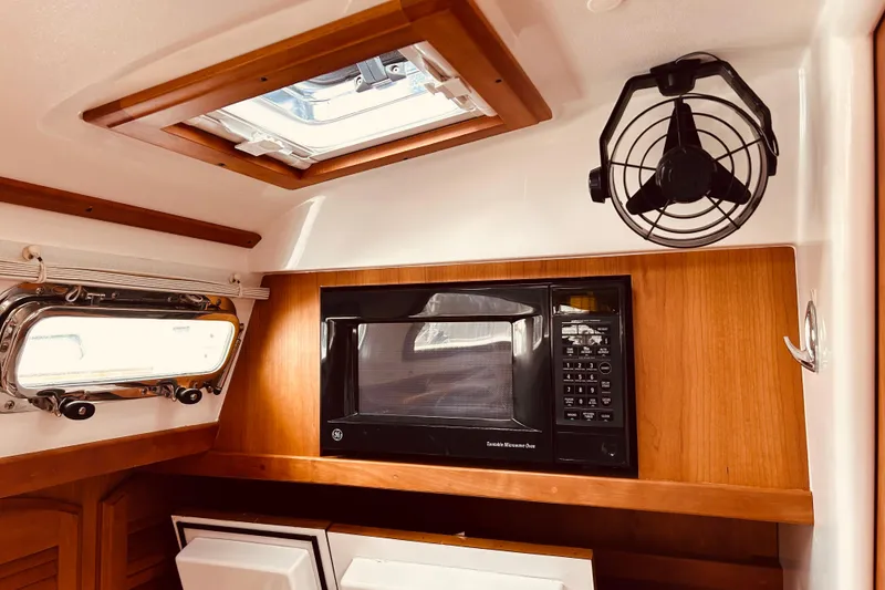 Slide: The Image of 2004 Sabre 426 yacht interior with microwave, fan, and porthole window. - 28