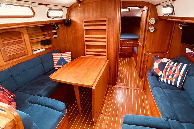 Slide: The Image of Interior of 2004 Sabre 426 sailboat with wooden furnishings and blue seating. - 29