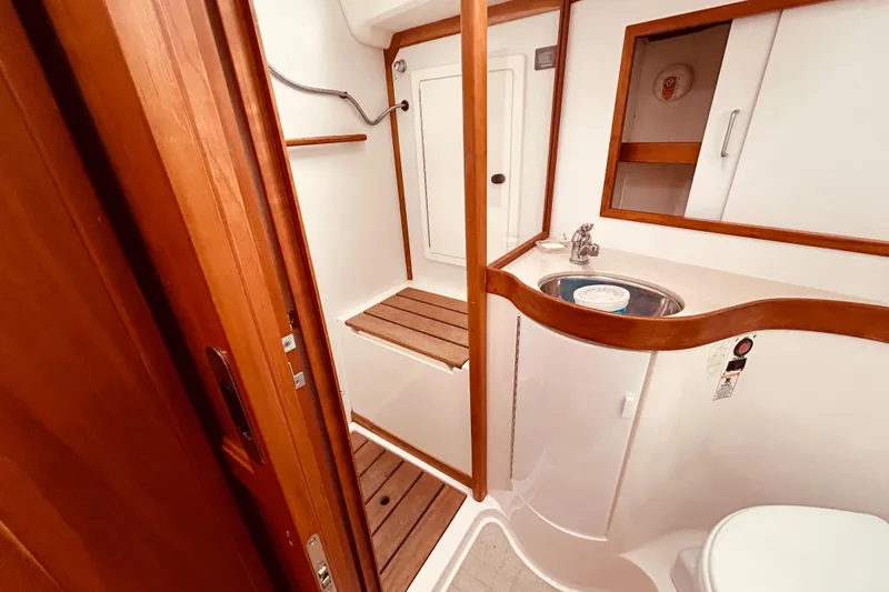 Slide: The Image of 2004 Sabre 426 yacht bathroom with wooden accents, sink, and shower area. - 37