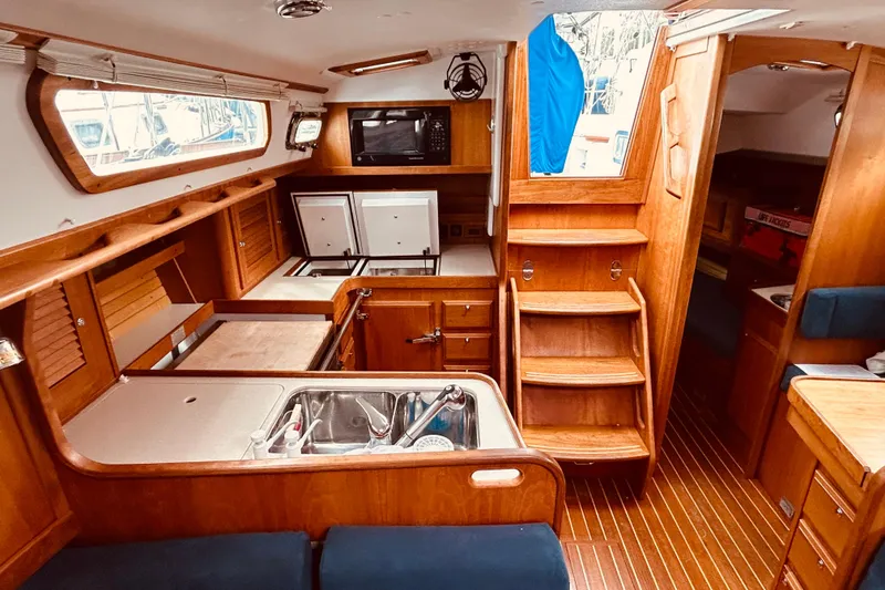 Slide: The Image of Interior of a 2004 Sabre 426 sailboat featuring a wooden galley and stairs. - 40