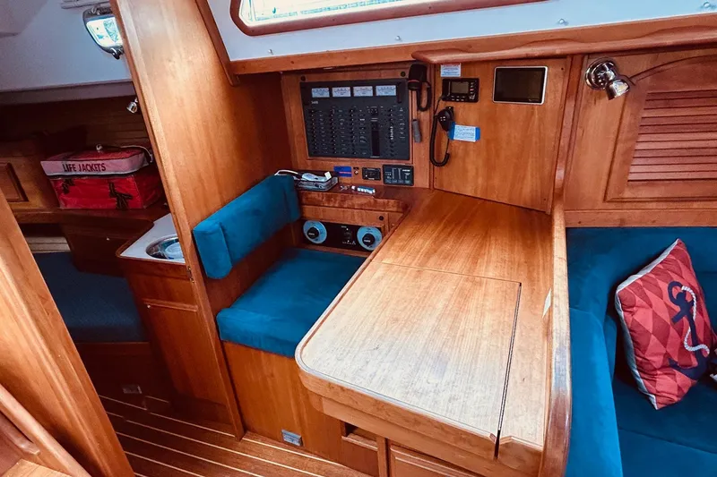 Slide: The Image of Interior of 2004 Sabre 426 sailboat with wooden navigation station and blue seating. - 44