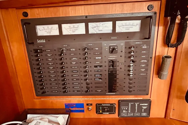 Slide: The Image of Electrical control panel of a 2004 Sabre 426 yacht with various switches and meters. - 46