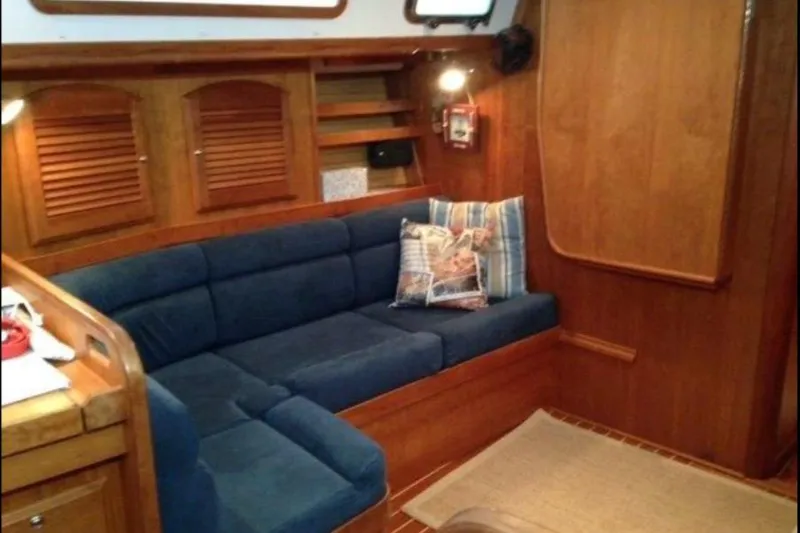 Slide: The Image of Interior of 2004 Sabre 426 yacht with blue sofa and wooden cabinetry. - 5
