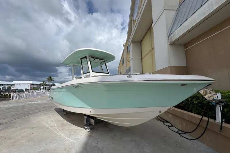 Slide: The Image of 2023 Robalo R272 Center Console boat displayed outdoors under cloudy sky. - 1