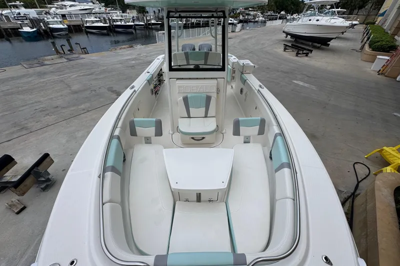 Slide: The Image of 2023 Robalo R272 Center Console boat with spacious seating at a marina. - 10