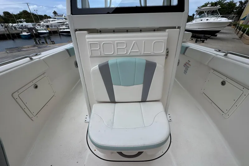 Slide: The Image of 2023 Robalo R272 Center Console boat seat with logo, docked at marina. - 12