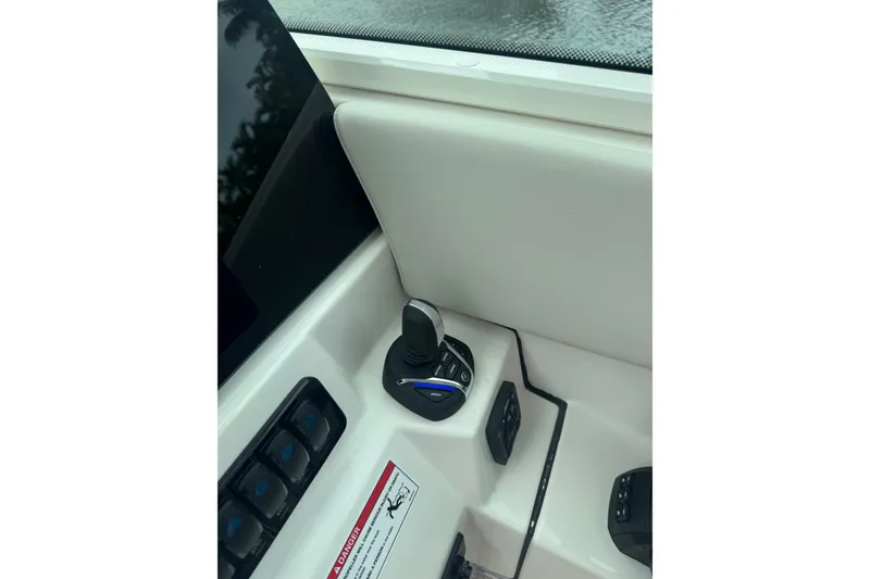 Slide: The Image of 2023 Robalo R272 Center Console boat control panel with joystick and switches. - 15