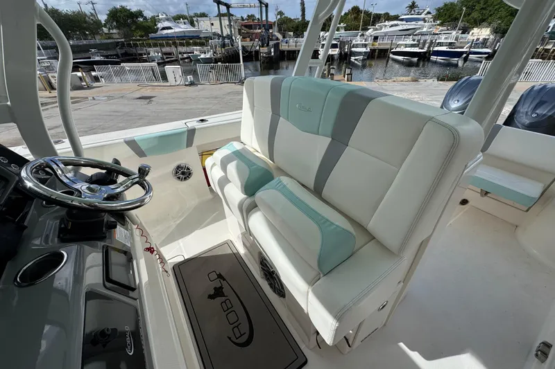 Slide: The Image of 2023 Robalo R272 Center Console boat interior with helm and seating, docked at marina. - 7