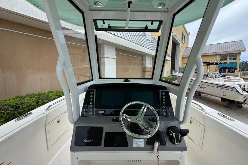 Slide: The Image of 2023 Robalo R272 Center Console boat helm with modern controls and steering wheel. - 9