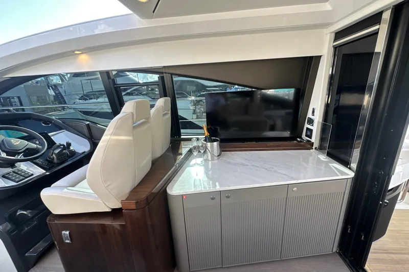 Slide: The Image of Interior of 2026 Fairline Targa 47 GT yacht with helm, seating, and entertainment area. - 19