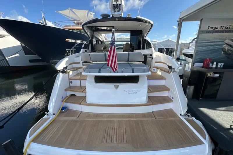 Slide: The Image of Fairline Targa 47 GT 2026 yacht with American flag, docked at marina. - 9