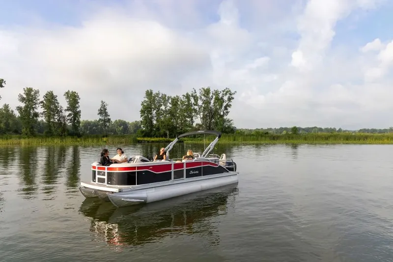 The Image of 2024 Barletta Aria pontoon boat on a calm lake with trees in the background. - 0