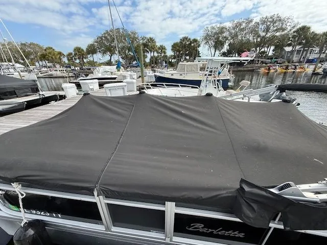 Slide: The Image of 2024 Barletta Aria pontoon boat docked with cover. - 6