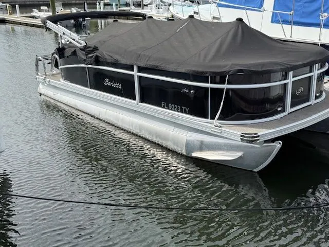 Slide: The Image of 2024 Barletta Aria pontoon boat docked with black cover. - 9