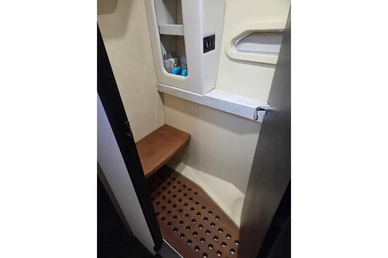 Slide: The Image of 2021 Regal 38 Grande Coupe bathroom with wooden seat and storage shelves. - 12