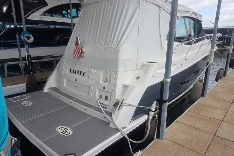 Slide: The Image of 2021 Regal 38 Grande Coupe docked, featuring sleek design and American flag. - 2