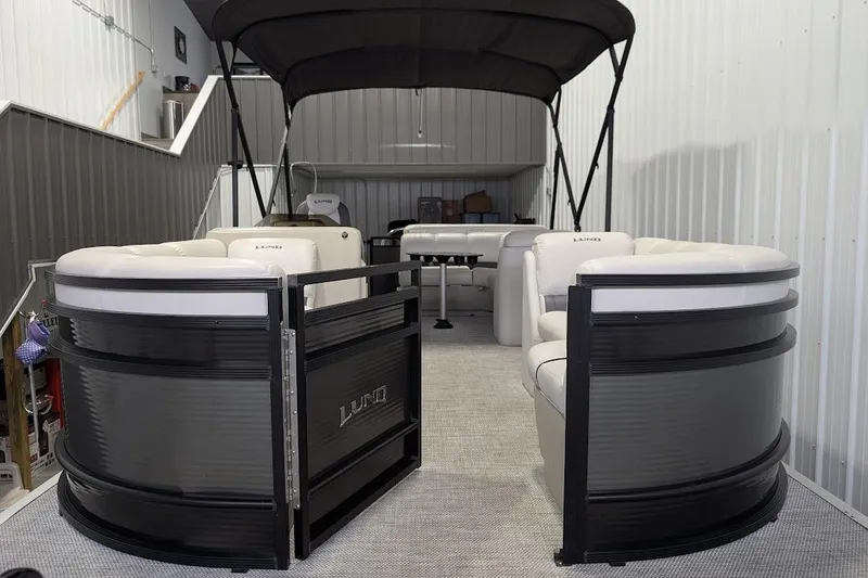 Slide: The Image of 2018 Lund LX220 Pontoon boat with seating, stored indoors. - 10