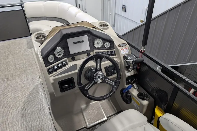 Slide: The Image of 2018 Lund LX220 Pontoon boat dashboard with steering wheel and Simrad display. - 15