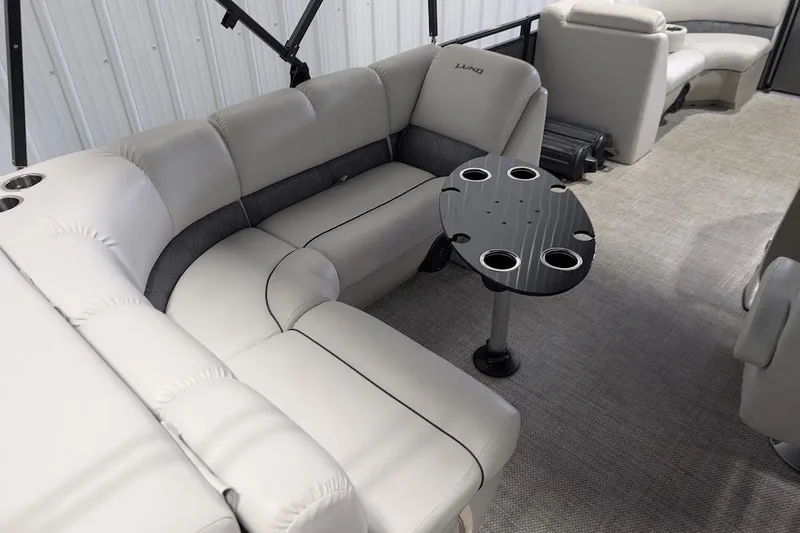 Slide: The Image of 2018 Lund LX220 Pontoon interior with plush seating and a round table with cup holders. - 22