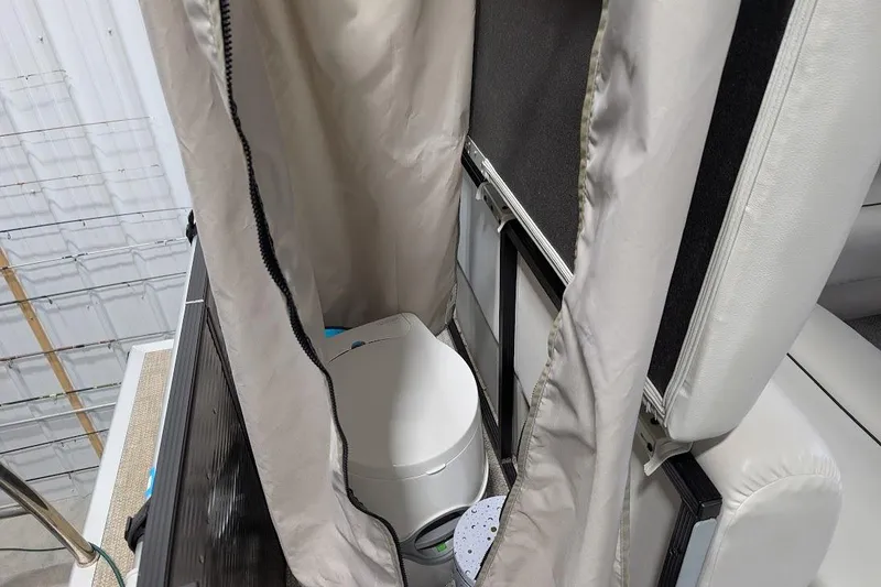 Slide: The Image of 2018 Lund LX220 Pontoon interior with portable toilet and privacy curtain. - 25